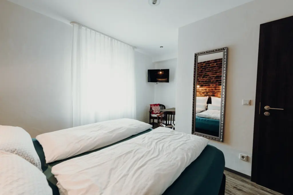 Hotelzimmer mit zwei Einzelbetten und großem Fenster